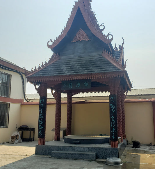 An ornate traditional Chinese carved structure over a sealed well. Chinese characters reading "White Sand Well". On the lot of Wang Zong's Hand Made Tea Factory.