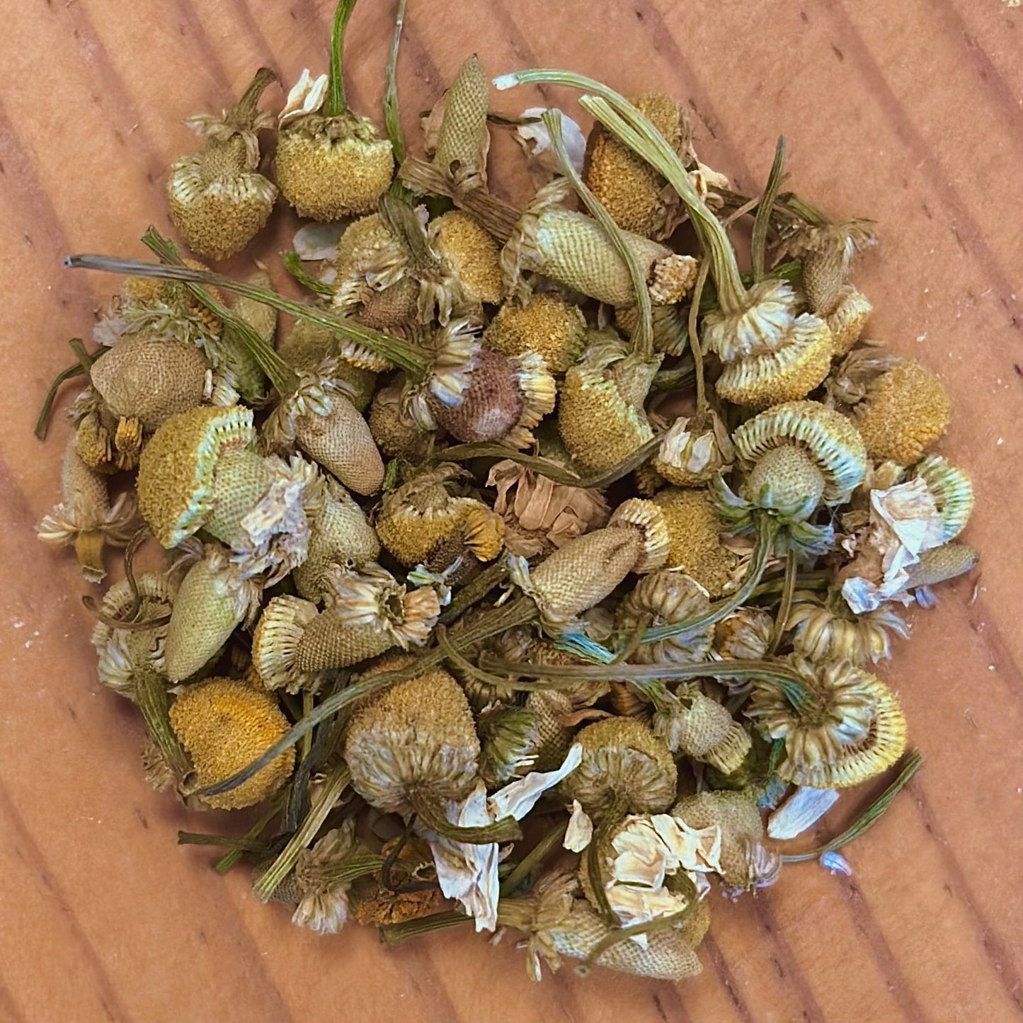 Dried chamomile flowers on a wooden surface