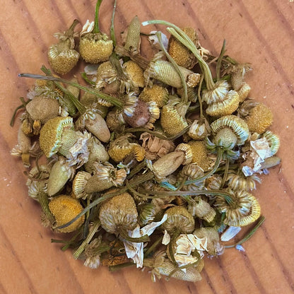 Dried chamomile flowers on a wooden surface