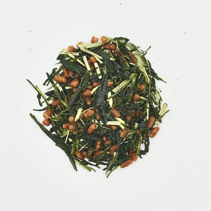 Green tea leaves with toasted brown rice on a white background