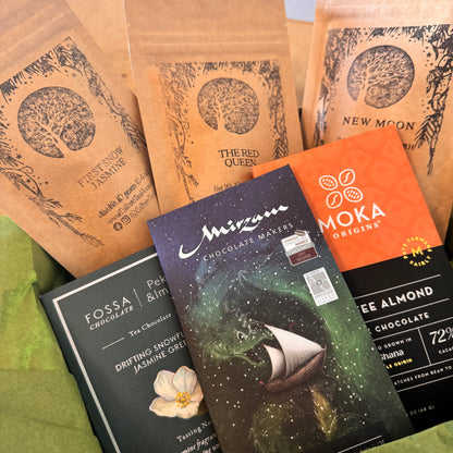 Collection of chocolate packaging and trea packages on a green surface