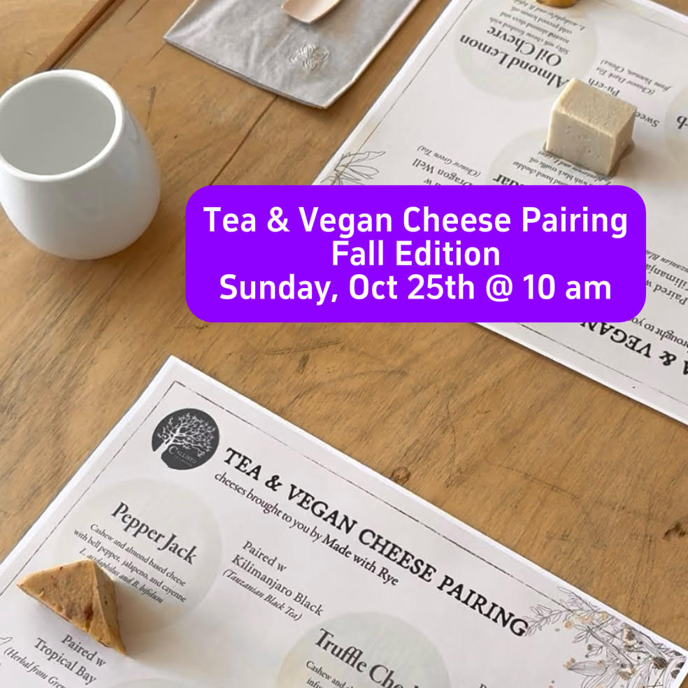 A styled flat-lay of printed tea and vegan cheese pairing cards on a wooden table, with a white ceramic cup, a small square of cheese, and a purple text banner reading 'Tea & Vegan Cheese Pairing Fall Edition Sunday, Oct 25th @ 10am'.