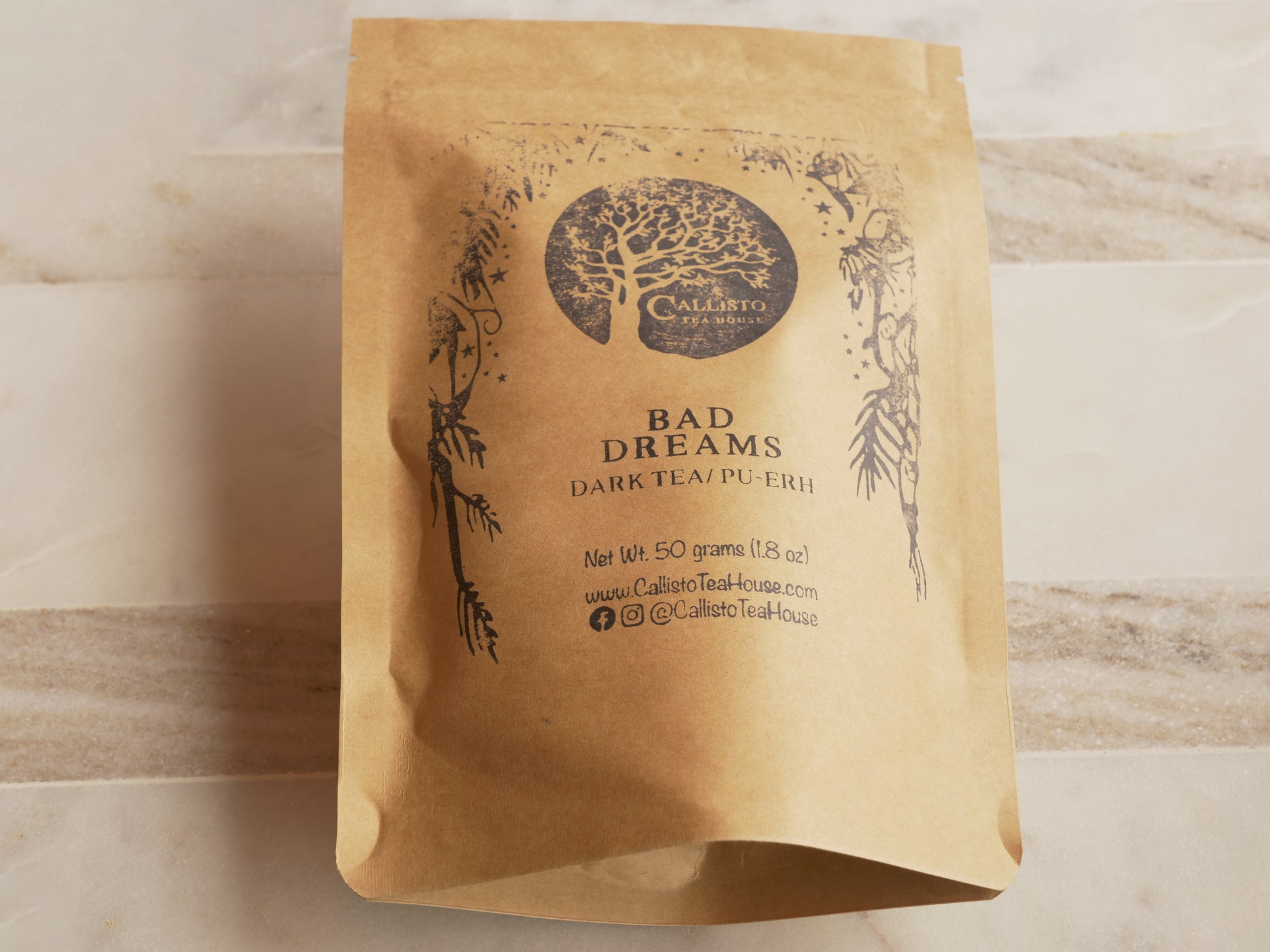 Kraft paper tea bag with 'Bad Dreams' dark tea label on a wooden surface