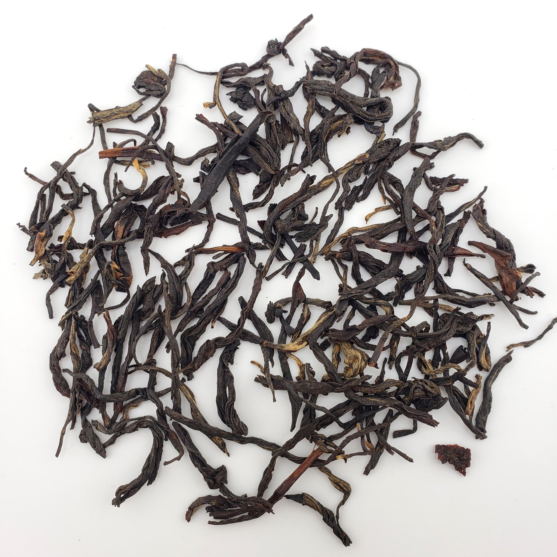 Dry black tea leaves on a white background