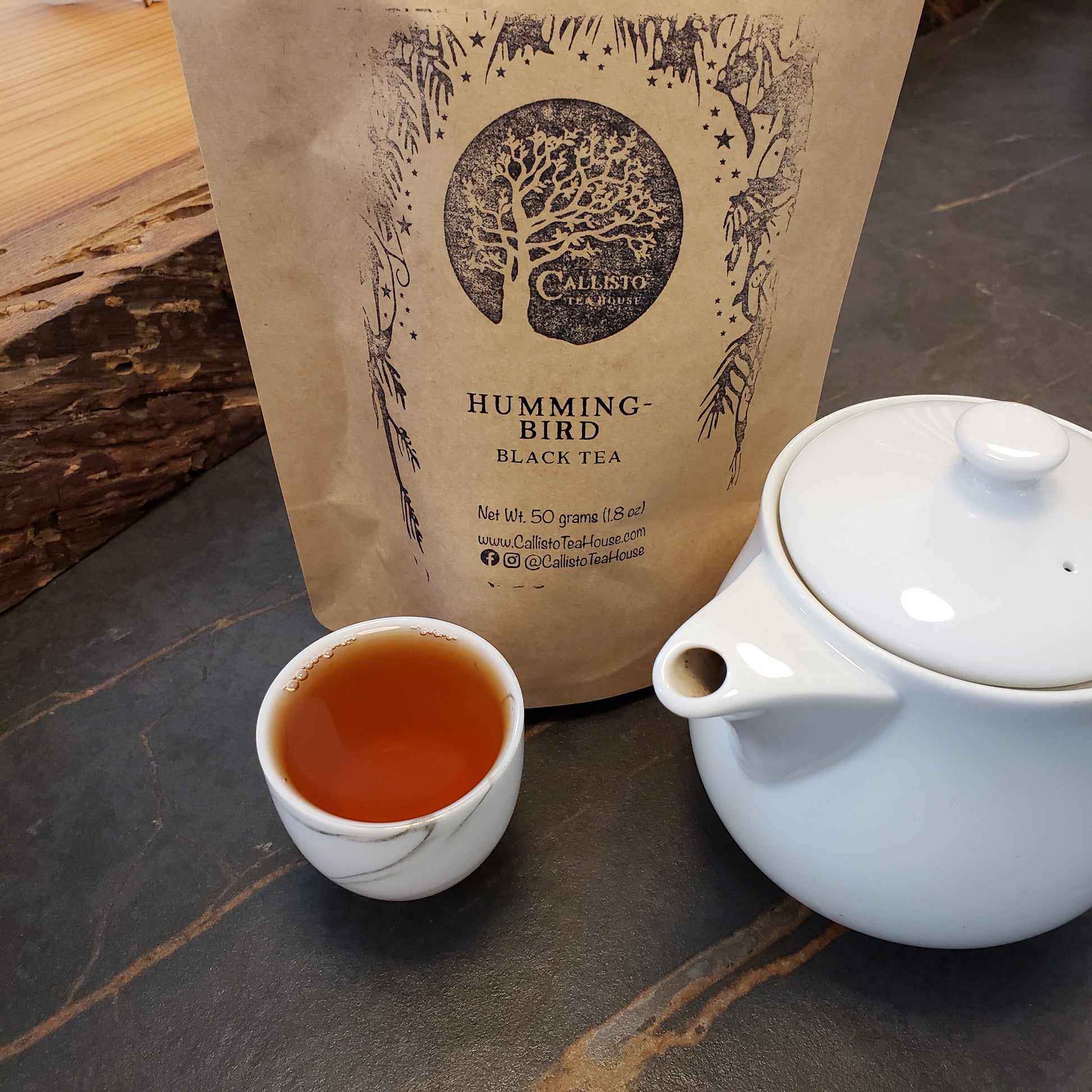 Tea packaging with a teacup and teapot on a wooden surface
