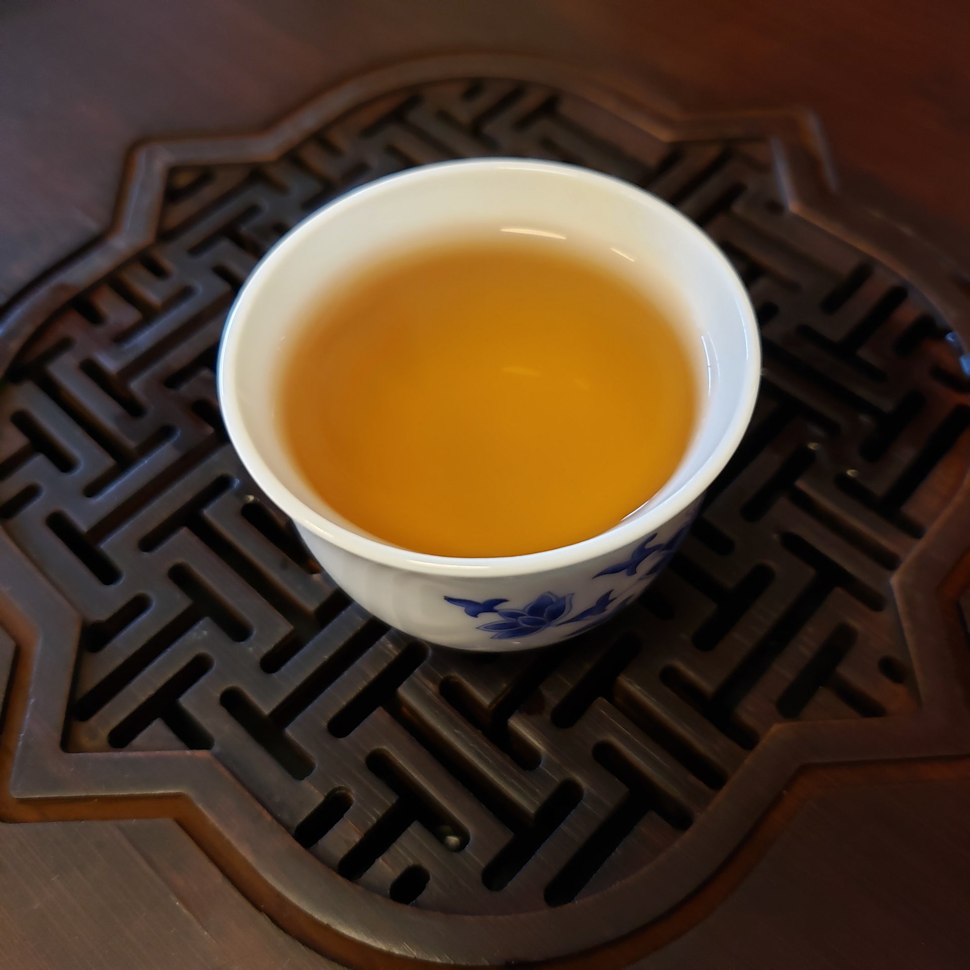 Tea cup with brewed tea on a decorative wood lattice tray