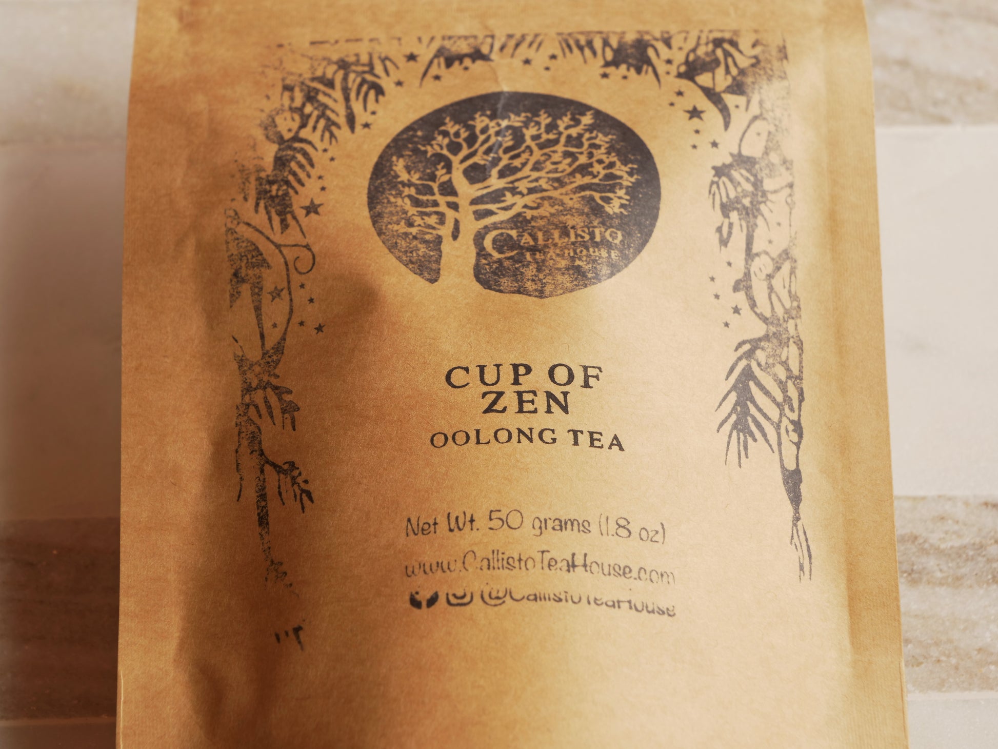 Tea bag packaging with 'Cup of Zen Oolong Tea' text and Calisto Tea House branding.