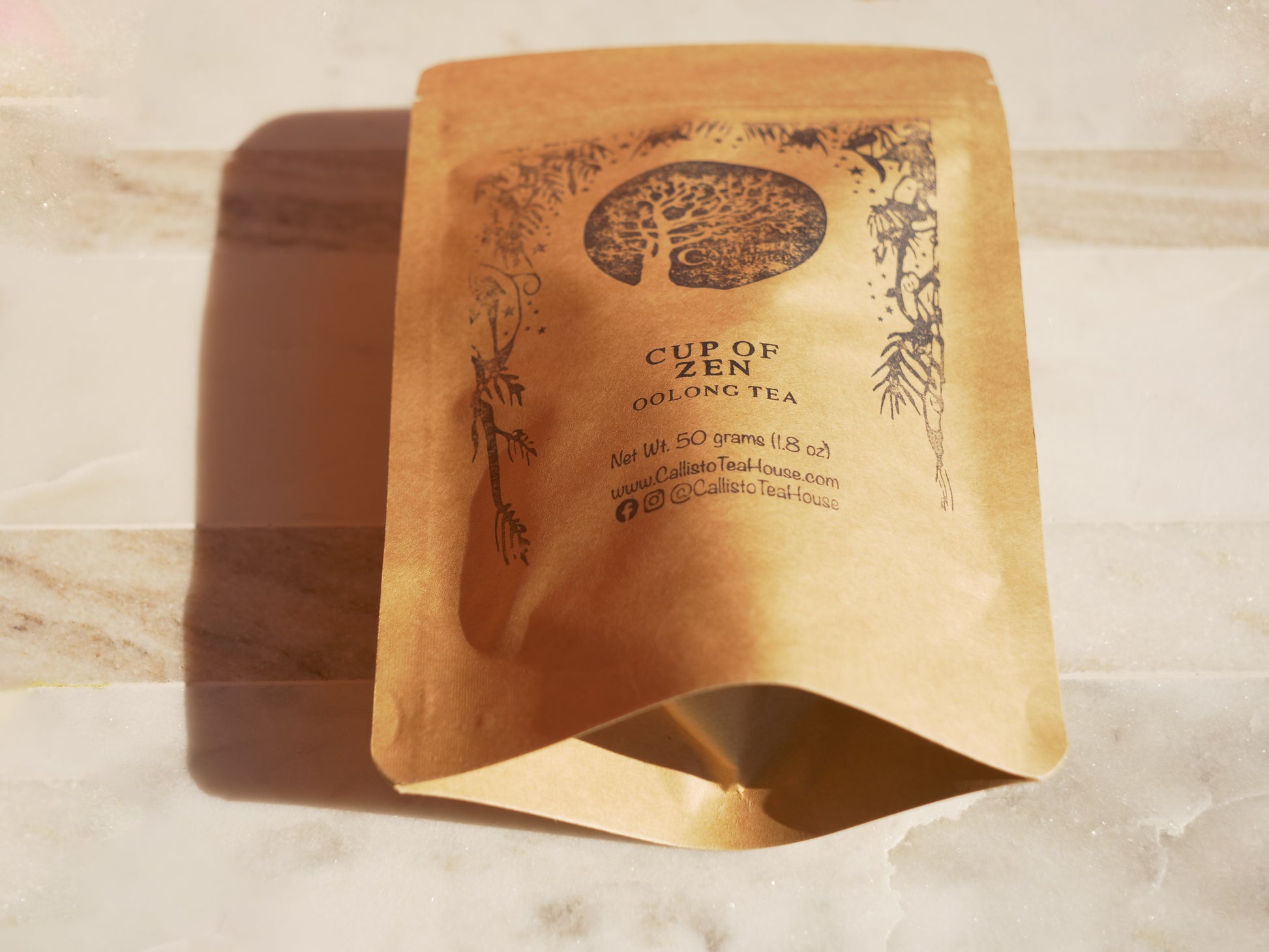 Tea package with 'Cup of Zen' branding on a marble surface