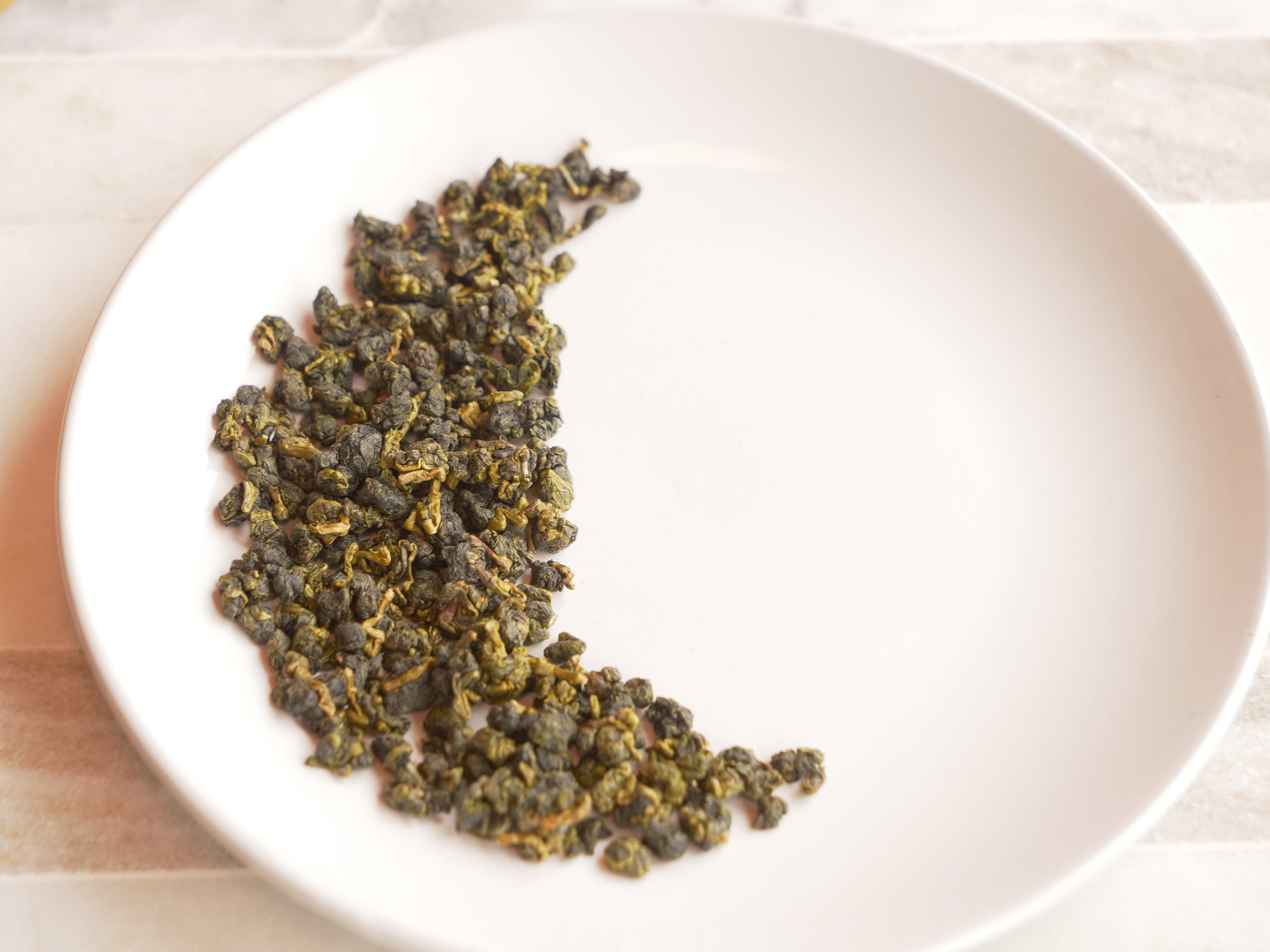 Dry tea leaves on a white plate