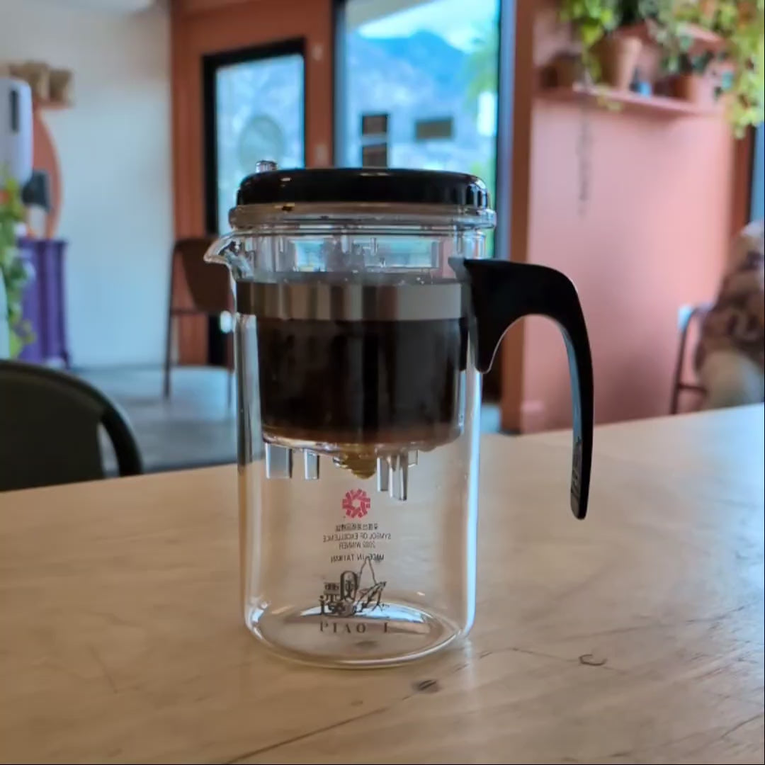 Video showing tea being dispensed from the upper brewing chamber into the body of the teapot.